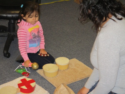 A mother and daughter are playing with toys that make sound